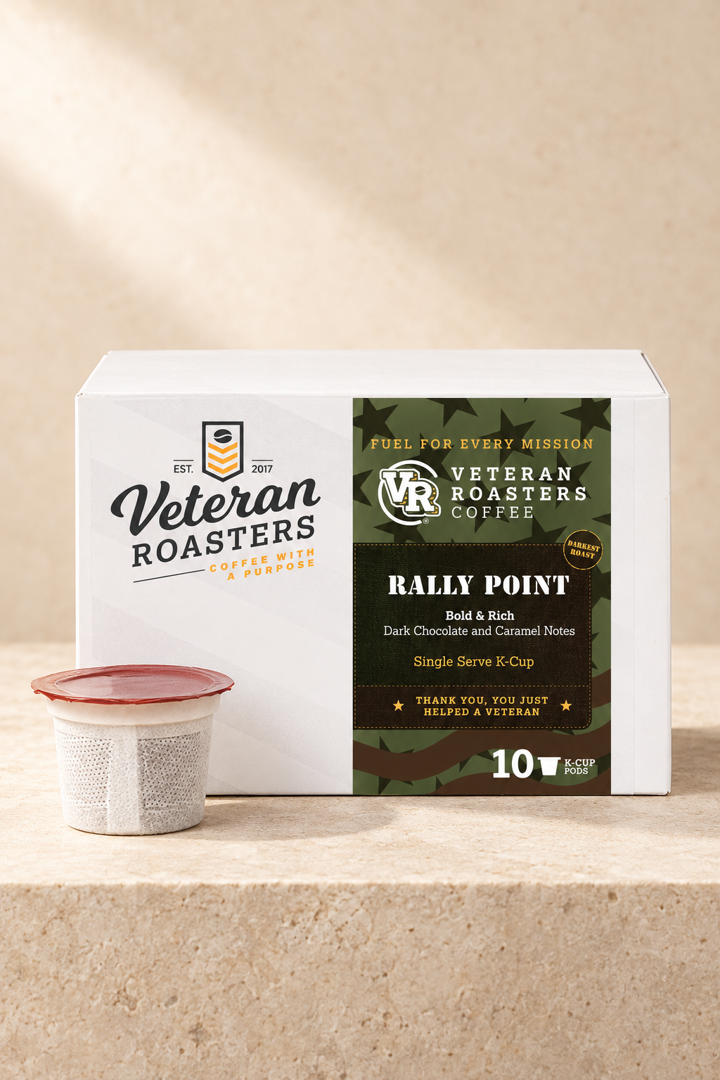 Rally Point darkest roast K-Cups, 10-count box with a single coffee pod on a light stone surface.